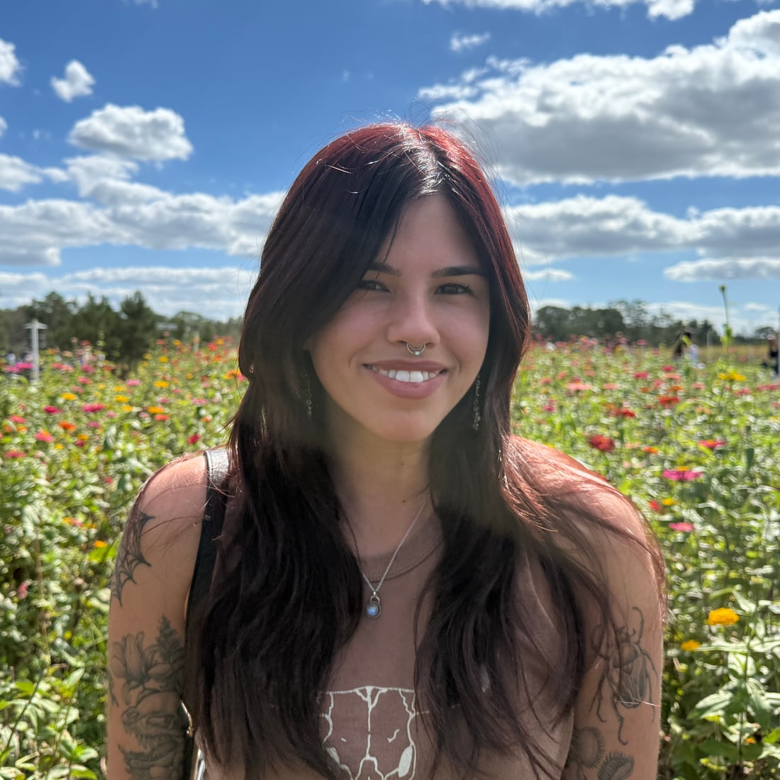 Everson, the owner of PlantBones, standing in a sunflower field under a bright Florida sky